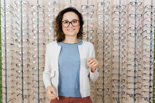 Cheerful Woman Looking Camera Assortment Eyeglasses Optics Shop — Fotografia de Stock