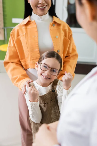 Happy Girl Eyeglasses Smiling Mom Blurred Ophthalmologist Optics Shop — Zdjęcie stockowe