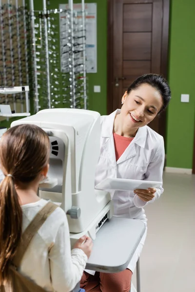 Oculista Sonriente Con Tableta Digital Que Prueba Vista Del Niño — Foto de Stock