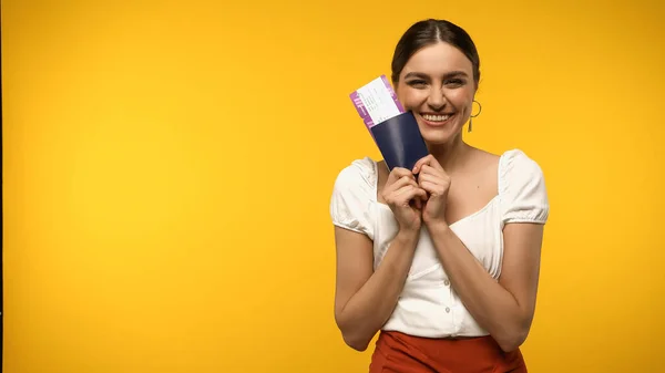 Mujer Morena Sonriendo Mientras Sostiene Pasaporte Billete Avión Aislado Amarillo — Foto de Stock