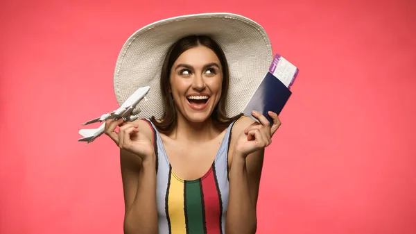 Positive Woman Sun Hat Holding Passport Toy Plane Isolated Pink — Foto de Stock