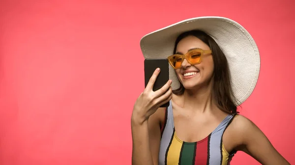 Happy Woman Sun Hat Swimsuit Using Mobile Phone Isolated Pink — Fotografie, imagine de stoc