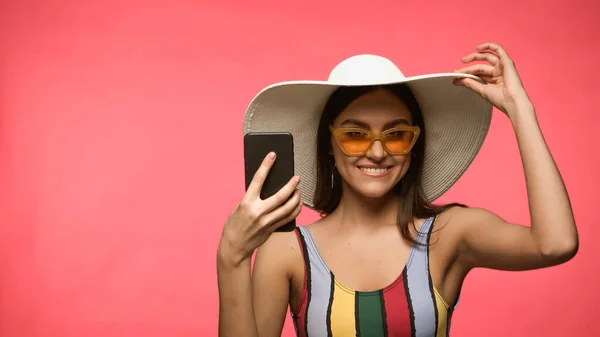 Happy Woman Sun Hat Swimwear Holding Cellphone Looking Camera Isolated — Fotografie, imagine de stoc
