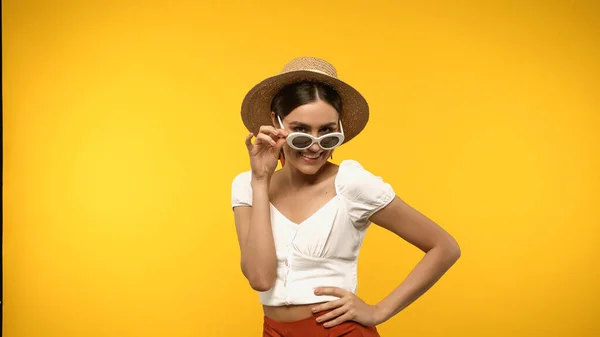 Positive Woman Straw Hat Sunglasses Holding Hand Hip Isolated Yellow — Zdjęcie stockowe