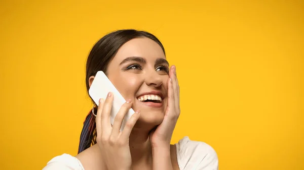 Pretty Woman Touching Cheek While Talking Smartphone Isolated Yellow — Fotografie, imagine de stoc