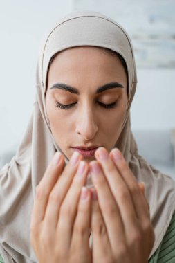 Genç Arap kadının portresi. Gözleri kapalı dua ediyor. 