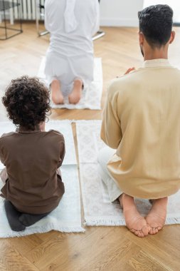 Arap baba ve oğlunun evde büyükbabalarının yanında dua edişinin arkası. 
