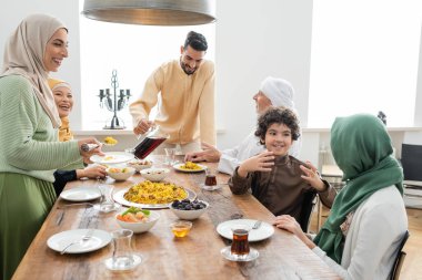 Mutlu ırklar arası aile pilav servisi yapıyor ve akşam yemeğinin yanına çay koyuyor. 