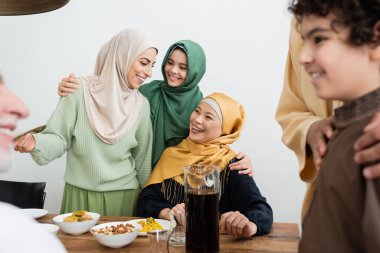Memlekette yiyecek ve ailelerin yanında konuşan pozitif çok ırklı kadınlar 