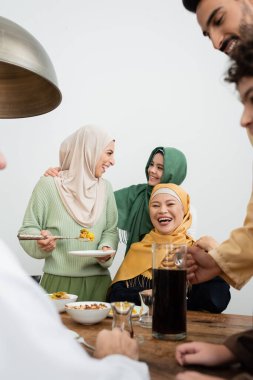 Memlekette yemek yiyen neşeli, etnik çeşitlilikte Müslüman bir aile. 
