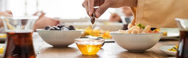 Müslüman adamın baklava yakınlarında bala batırma ve bulanık çay ve pankart manzarası