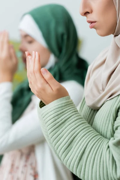 Jonge Moslim Vrouw Bidden Buurt Wazig Tiener Dochter Thuis — Stockfoto