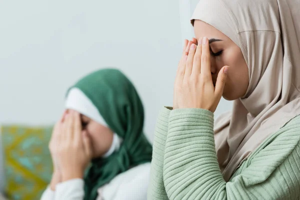 自宅で娘の近くで祈っている間に顔を覆うアラビア人女性 — ストック写真