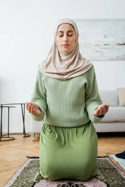 Арабская Женщина Хиджабе Молится Традиционном Ковре Дома — стоковое фото
