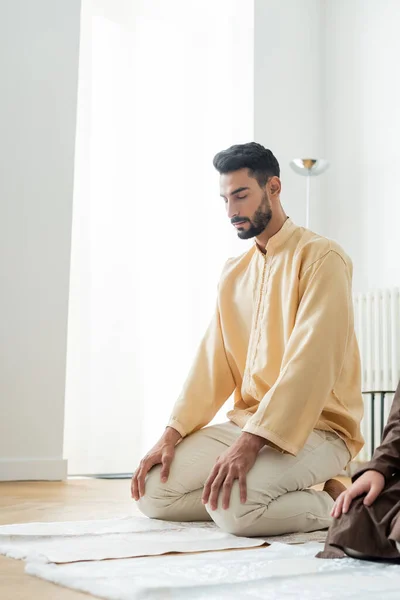 Jeune Homme Arabe Priant Sur Tapis Près Fils Préadolescent Maison — Photo