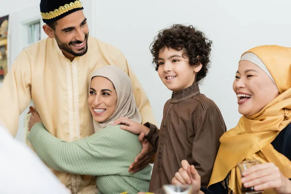 在快乐的穆斯林父母和亚洲祖母身边笑着的阿拉伯男孩 — 图库照片