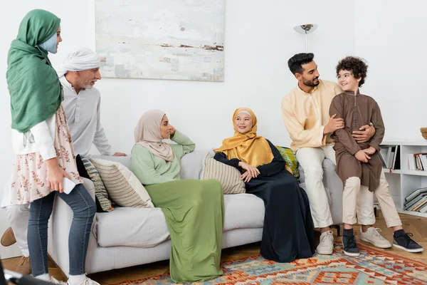 Joven Árabe Hombre Abrazando Hijo Cerca Multicultural Musulmán Familia Casa — Foto de Stock