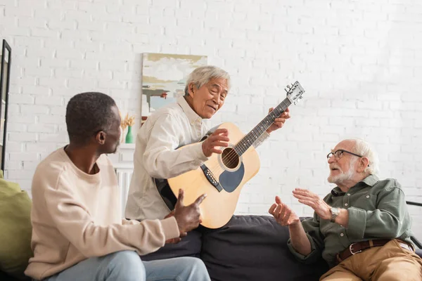 Ancianos Amigos Multiétnicos Hablando Con Hombre Asiático Con Guitarra Acústica — Foto de Stock