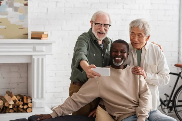 Anciano Tomando Selfie Smartphone Cerca Amigos Multiétnicos Casa — Foto de Stock