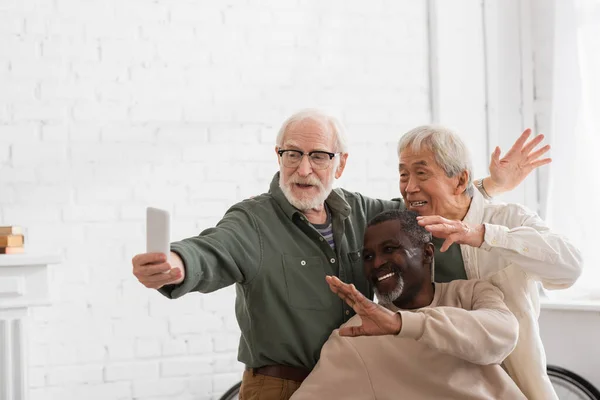 Ancianos Amigos Multiétnicos Que Tienen Videollamada Teléfono Inteligente Casa — Foto de Stock