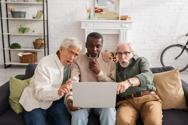 Geschokt Multi Etnische Senior Vrienden Zoek Naar Laptop Thuis — Stockfoto