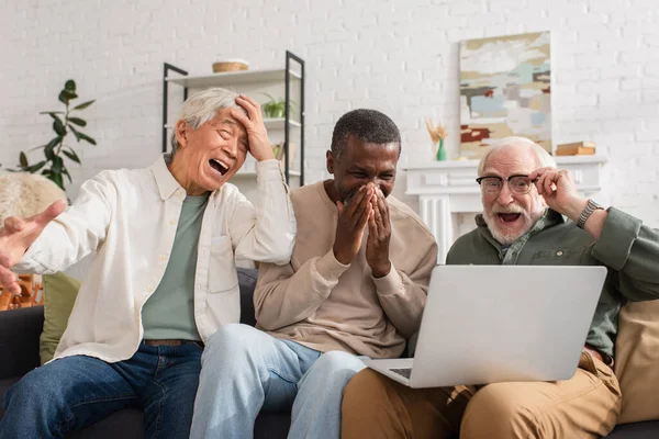 Lachen Interraciale Vrienden Met Behulp Van Laptop Bank Woonkamer — Stockfoto