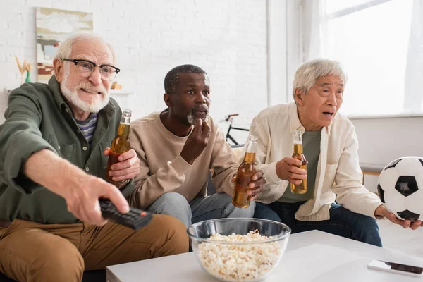 Multietnické Starší Přátelé Drží Pivo Fotbal Popcornu Doma — Stock fotografie