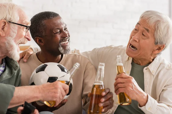 Excited Interracial Senior Friends Holding Beer Bottles Football Home — Stock Photo, Image