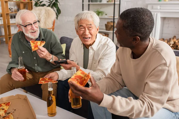 Positive Interracial Senior Men Holding Pizza Remote Controller Beer Home — Stock Photo, Image