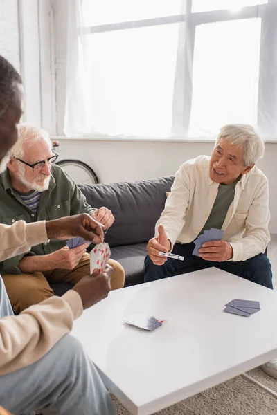 Smiling Asian Man Playing Cards Interracial Senior Friends Home — Stock Photo, Image