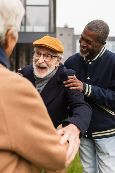 Веселый Пожилой Мужчина Обнимает Размытого Друга Рядом Африканским Американцем Городской — стоковое фото
