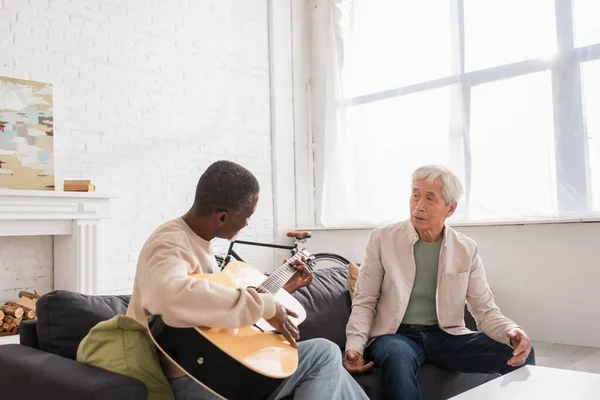 Interracial Pensioners Playing Acoustic Guitar Couch Home — Stock Photo, Image