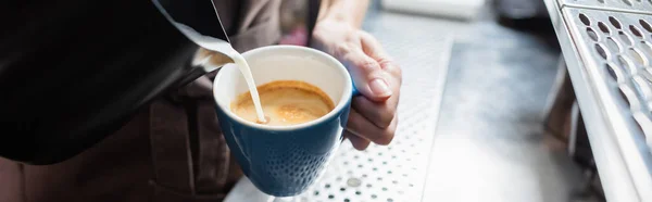カフェ バナーでコーヒーにミルクを注ぐバリスタの作物ビュー — ストック写真