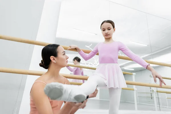 Ung Danslärare Som Håller Flickans Ben Och Övar Balettskolan — Stockfoto