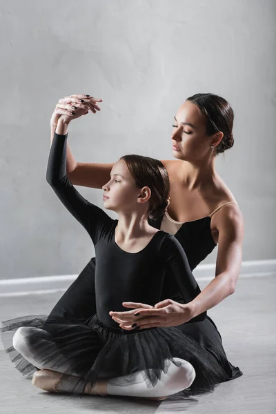 Flicka Sitter Med Korsade Ben Nära Balett Lärare Visar Koreografiska — Stockfoto