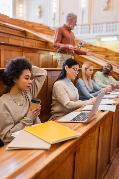 Studente Afroamericano Possesso Caffè Vicino Laptop Sfocato Amici Interrazziale Università — Foto Stock