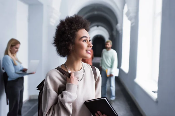 Estudante Afro Americano Positivo Segurando Mochila Caderno Corredor Universitário — Fotografia de Stock