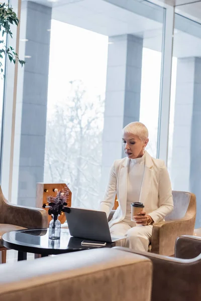 Mulher Negócios Elegante Sentado Com Café Para Perto Laptop Salão — Fotografia de Stock