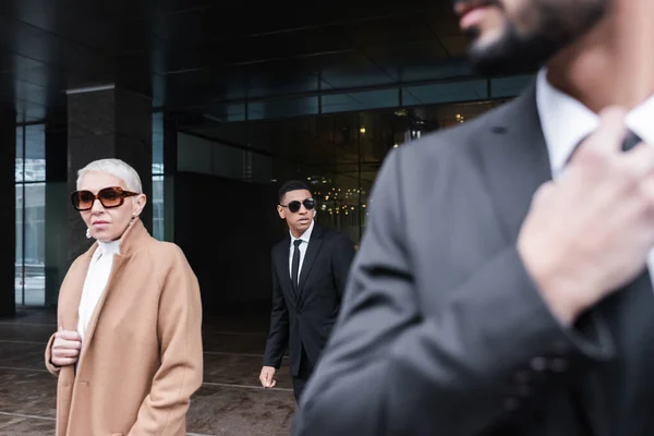 Mature Businesswoman Sunglasses Hotel Entrance Multiethnic Bodyguards — Stock Photo, Image