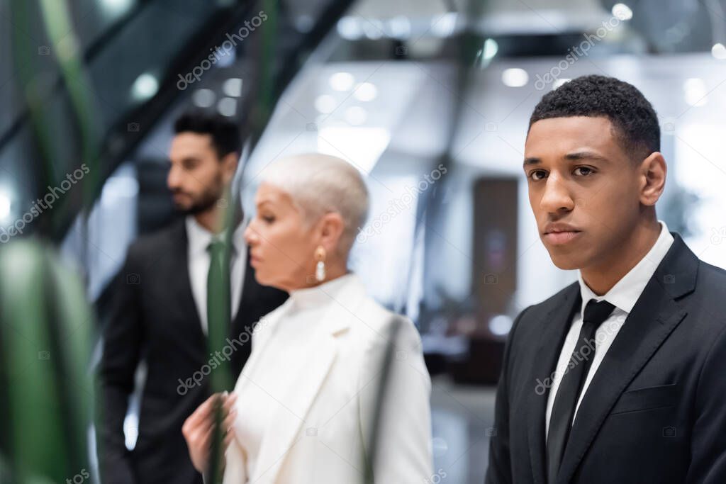 selective focus of african american security man near blurred businesswoman with bi-racial bodyguard in hotel