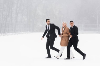 full length view of multiethnic bodyguards protecting mature businesswoman walking on winter field clipart