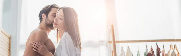 恥知らずな男は絹のローブで若い女性にキス バナー — ストック写真