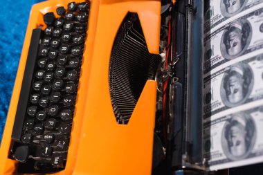 top view of retro typewriter and dollar banknotes, blurred foreground clipart
