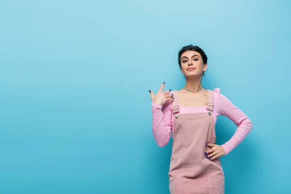 Zelfbewuste Vrouw Staan Met Hand Heup Glimlachen Blauwe Achtergrond — Stockfoto