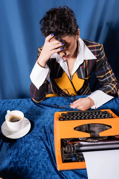 Periodista Agotado Sosteniendo Anteojos Cerca Máquina Escribir Vintage Taza Café —  Fotos de Stock