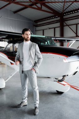 Takım elbiseli kendine güvenen işadamlarının hepsi modern helikopterin yanında el ele duruyorlar.