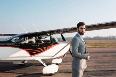 Açık havada helikopterin yanında duran takım elbiseli başarılı bir işadamı. 