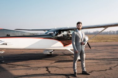 Modern helikopterin yanında duran ve spor ceketi ayarlayan kendine güvenen işadamlarıyla dolu.