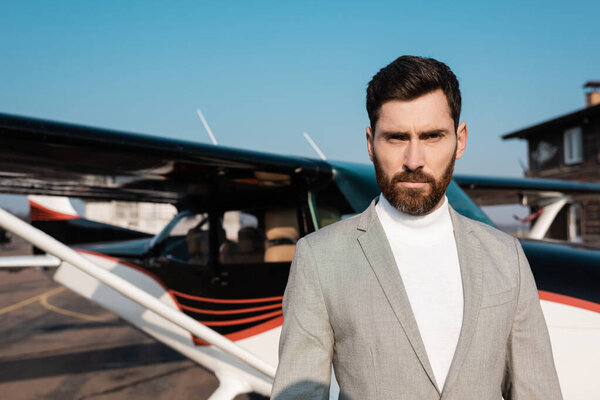 businessman in suit standing near blurred helicopter outdoors 