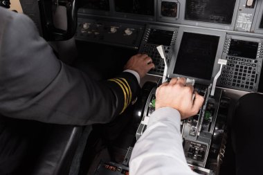 Yardımcı pilotun uçak simülatöründe kaptana yakın itme kolu kullanmasının yüksek açılı görüntüsü